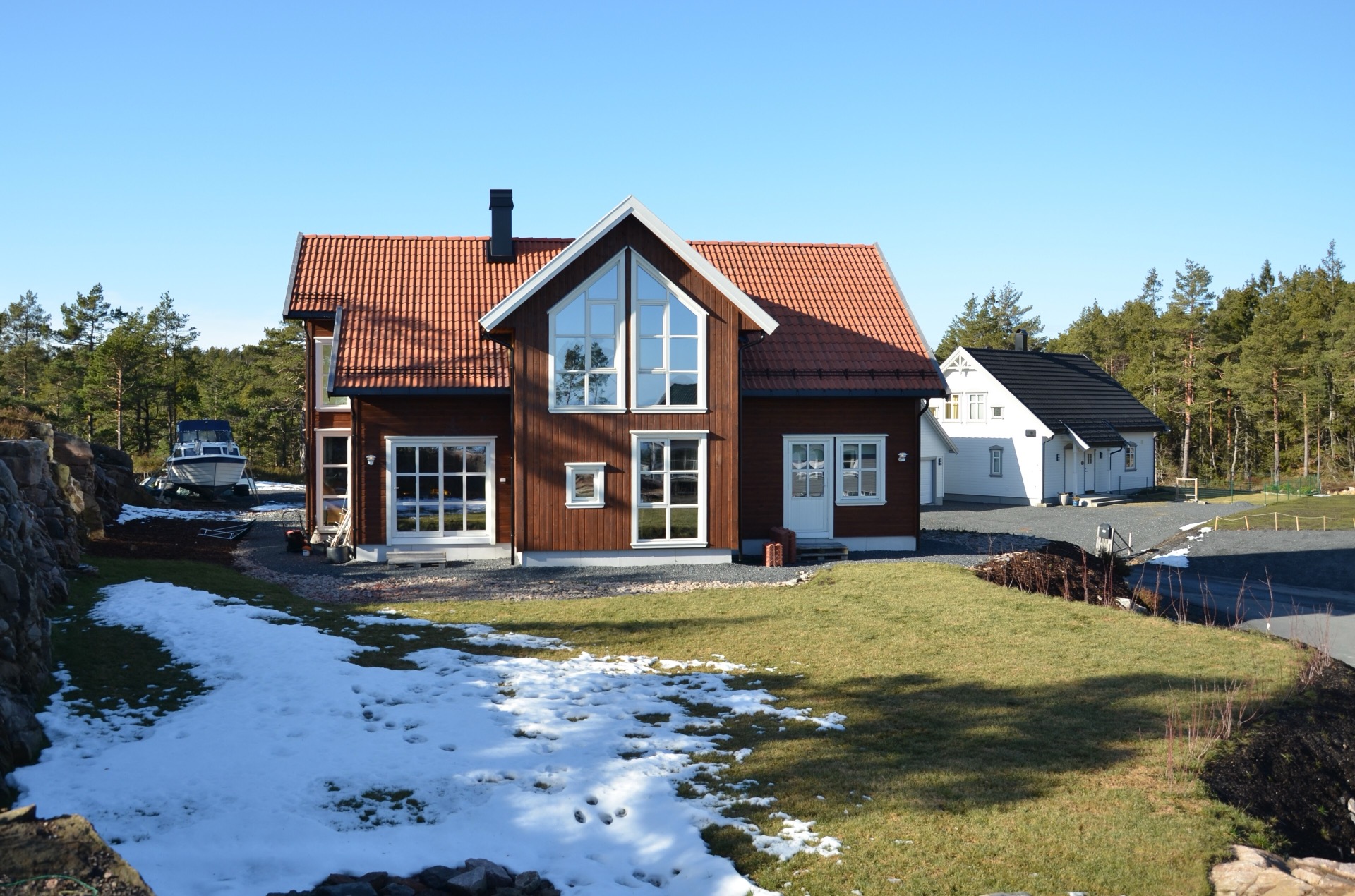 Rött nybyggt trähus med stora gavelfönster — referensbild, inte ett Kult-bygge.